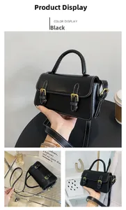 Detail of black leather square bag showing vintage flap with white contrast stitching