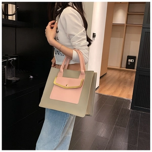 Detail of a large capacity tote bag with khaki body and pink flap pocket accents