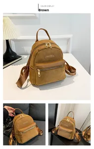Détail du mini sac à dos en daim marron avec fermetures dorées et étiquette en cuir mode