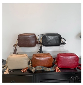 Close-up showing a collection of vintage crossbody camera bags in five classic colors