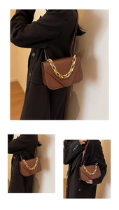Detailed close-up of dark brown crocodile pattern texture and gold chain on square bag