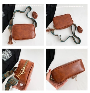 Detail view of vintage brown crossbody bag with bohemian strap and fringe charm