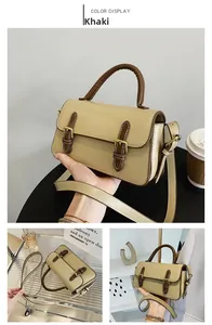 Detailed view of the khaki and dark brown contrast square handbag with metal buckles