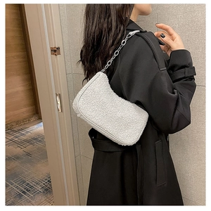 Détail du sac à bandoulière en peau lainée blanche avec une chaîne en métal argenté