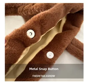 Vue détaillée du fermoir magnétique argenté sur un sac fourre-tout en peluche marron