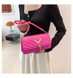 Macro view of rose pink quilted leather bag with gold V-metal hardware and tassel