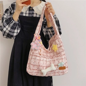 Detail der rosa Tweed-Einkaufstasche mit Plüsch-Anhängern und Leder-Namensschild
