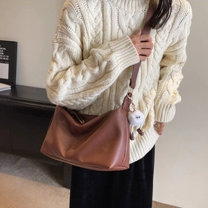 Brown faux leather tote bag with white faux fur pompom shown on model for daily commute