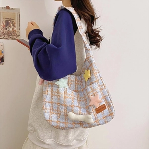 Detailansicht der blau-orange karierten Tweed-Tasche mit süßen Plüsch-Stern-Ornamenten