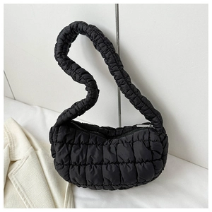 Detail of black quilted shoulder bag featuring ruffled straps and silver metal zipper closure