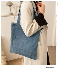 Detail of high-density denim tote bag with double front pockets on female model