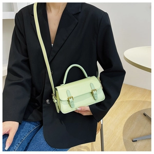 Detail of mint green vintage small square bag with decorative golden metal buckles