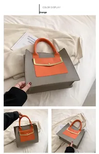 Detail of grey and orange contrast tote bag showing gold magnetic closure and stitching