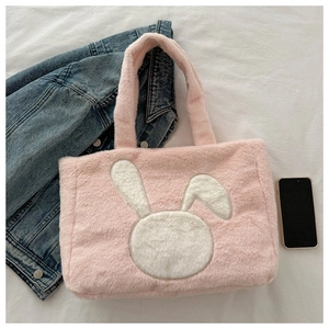 Vue détaillée du sac cabas en peluche rose avec un écusson lapin blanc et texture douce