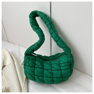 Close-up of bright green quilted shoulder bag with fluffy nylon texture and zipper