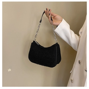 Détail d'un sac hobo en laine d'agneau noire avec chaîne argentée sur un mannequin