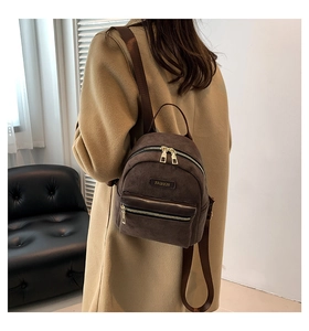 Détail de la texture en velours côtelé marron et des bretelles réglables d'un petit sac à dos