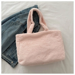 Détail de la texture d'un sac cabas en peluche rose avec une finition en fausse fourrure