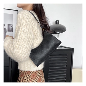 Detailaufnahme der minimalistischen schwarzen Leder-Achseltasche mit schmalem Gurt