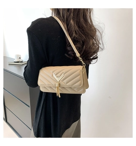 Quilted leather beige crossbody bag detail with gold V-hardware and stylish tassel