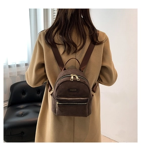 Vue arrière d'un mini sac à dos en velours marron sur un mannequin en manteau kaki