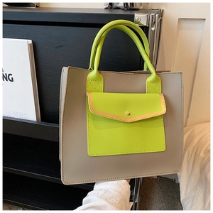 Detail of taupe leather tote bag featuring vibrant green handle and front envelope pocket