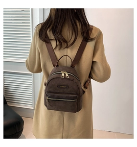 Détail du mini sac à dos marron foncé en daim porté sur le dos d'un mannequin chic