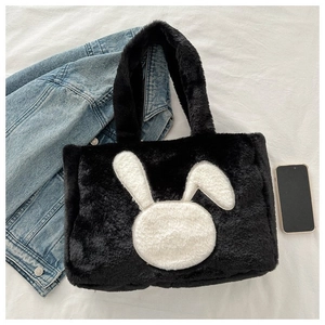 Détail d'un grand sac cabas en peluche noire avec un motif de lapin blanc tout doux