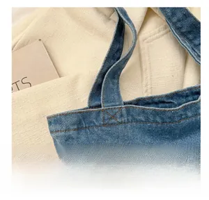Detailed macro view of heavy-duty stitching on washed denim tote bag handles