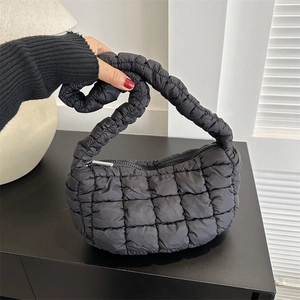 Minimalist black quilted puffer shoulder bag with puffy handles and zip closure