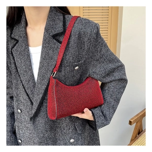 Detail der roten Glitzer-Schultertasche kombiniert mit grauem Tweed-Blazer