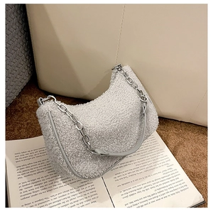 Détail d'un sac bandoulière en peau d'agneau duveteuse avec chaîne argentée et décor