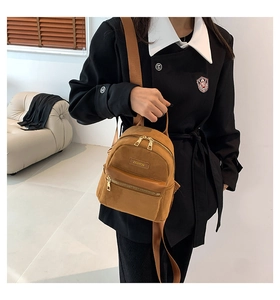 Vue détaillée de la texture velours marron et du zip doré sur ce mini sac à dos chic