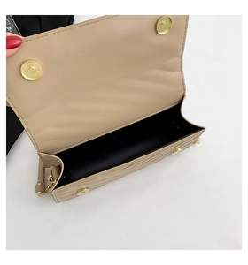 Detail view of the beige quilted crossbody bag showing magnetic snap closure and gold chain