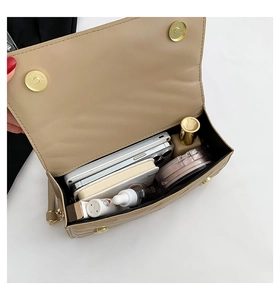 Internal view of beige quilted shoulder bag showing capacity for phone and cosmetics