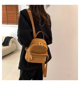 Détail d'un mini sac à dos en daim kaki avec ferrures dorées et gaufrage de mode