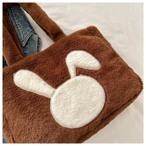 Détail du sac fourre-tout en peluche marron avec applique lapin blanc et poignées douces