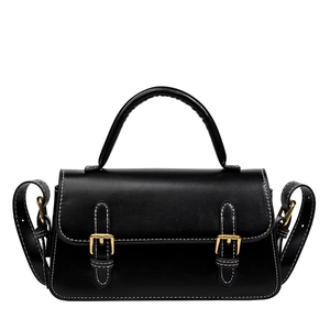 Vintage black crossbody bag with white stitching and golden buckles in a minimalist style