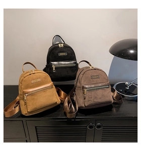 Vue détaillée de trois mini sacs à dos en velours côtelé noir, kaki et marron sur étagère