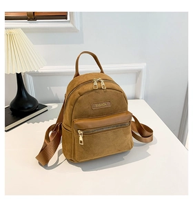 Détail d'un mini sac à dos marron en nubuck avec fermeture éclair dorée et logo