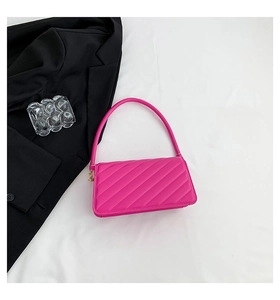 Detailed view of bright pink quilted shoulder bag with fine diagonal stitching texture