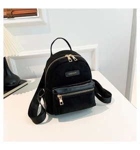 Détail d'un mini sac à dos noir avec poche en simili cuir et fermeture éclair dorée