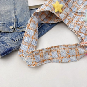 Detaillierte Nahaufnahme der blau-orange karierten Tweed-Tasche mit Sternanhänger