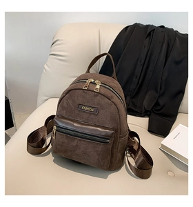 Détails de la texture velours du sac à dos marron foncé avec plaque en métal doré