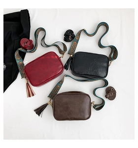 Three vintage crossbody bags with ethnic embroidered straps and long tassels in a flat lay