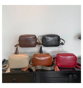 Five vintage small square bags with tassel details and ethnic print straps in various colors