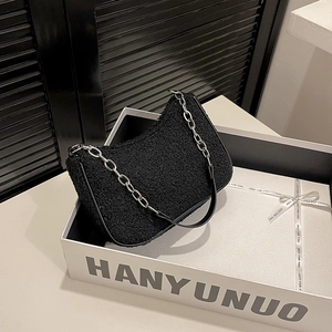 Chic sac d'épaule en fausse fourrure noire avec une fine bandoulière en métal argenté