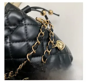 Detail showing quilted leather texture with gold metal chain and heart pendant