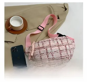 Detailansicht der rosa Tweed-Brusttasche mit verstellbarem Riemen auf flachem Hintergrund