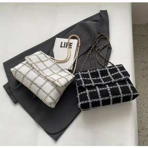 Détails de la texture en tweed et des bandoulières en chaîne de ces sacs à carreaux